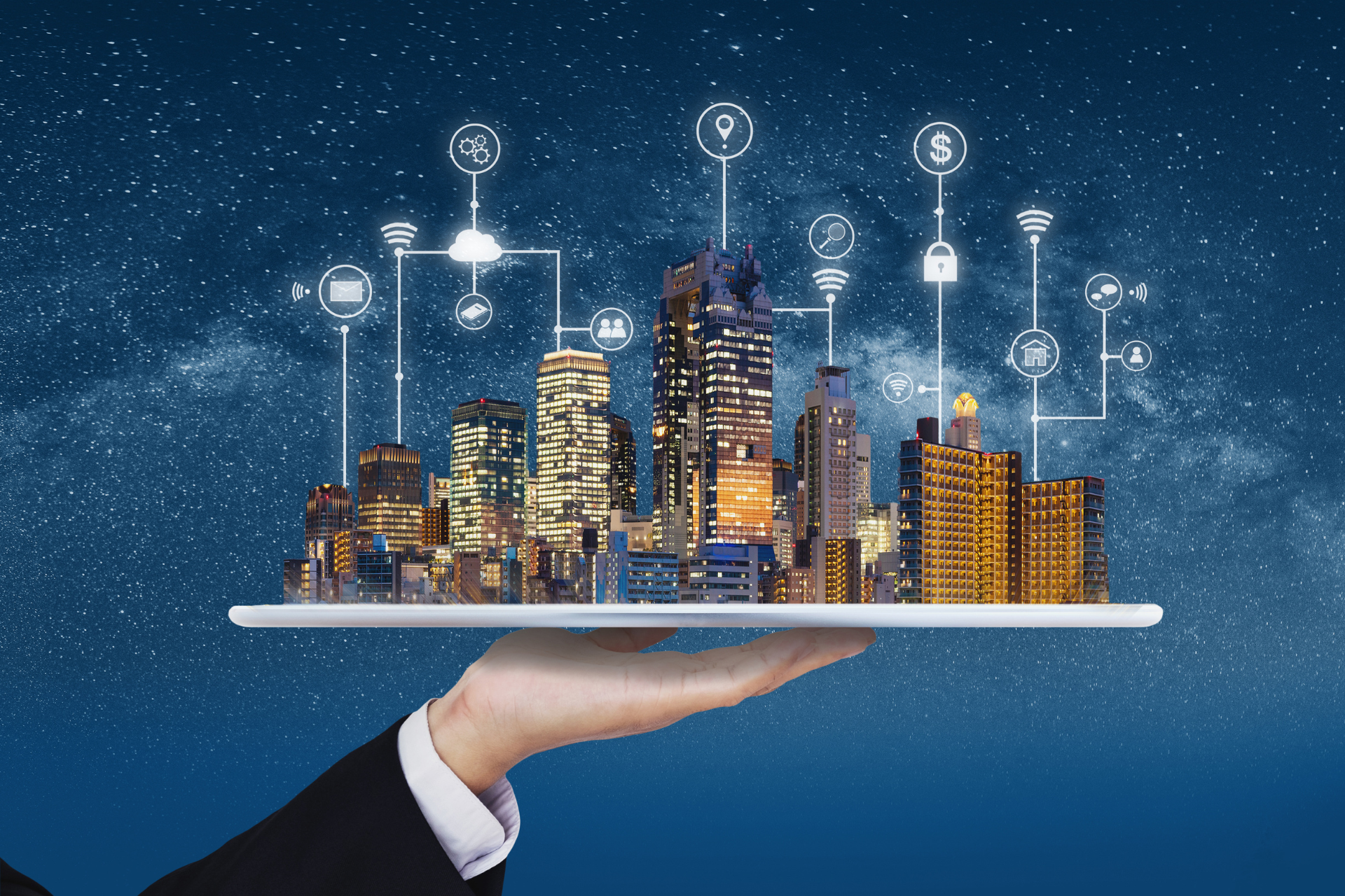 Main tenant une tablette avec une ville illuminée et des icônes technologiques connectées