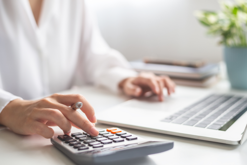 femme sur son ordinateur qui tape sur sa calculette
